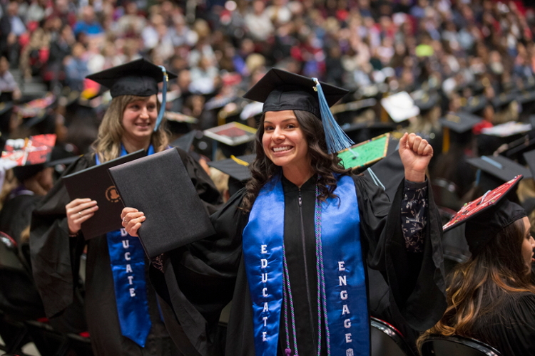 Student celebrates at Commencement wearing blue Educate and Engage stole